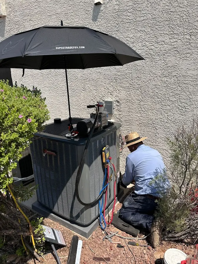 HVAC technician performing outdoor AC maintenance in Janesville